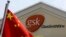 FILE - A Chinese flag is hoisted in front of a GlaxoSmithKline building in Shanghai, China. Police accused Peter Humphrey, a British executive of drug maker GlaxoSmithKline, on May 14, 2014, of leading a sprawling scheme to bribe doctors and hospitals to 