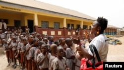 Jumoke Olowookere speaks to children at a school as she prepares them to repaint a playground made from used tires in Ibadan Nigeria on February 22, 2022. (REUTERS/Temilade Adelaja)