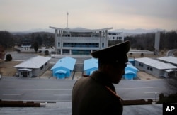 FILE - Korean People's Army Lt. Col. Nam Dong Ho is silhouetted against the truce village of Panmunjom at the Demilitarized Zone (DMZ) which separates the two Koreas, in Panmunjom, North Korea.