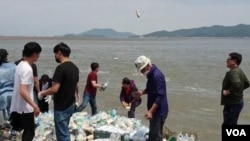 한국의 탈북자 단체 관계자들이 강화도에서 쌀과 이동식저장장치(USB) 등이 들어 있는 페트병을 바다에 던지고 있다. (자료사진)