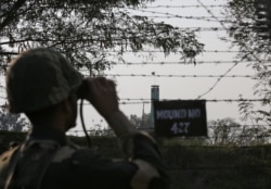 FILE - An Indian Border Security Force soldier keeps vigil during patrol along the fenced border with Pakistan in Ranbir Singh Pura sector near Jammu, Feb. 26, 2019.