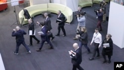 FILE - In this image made from video, Australia's Federal Police, top, enter the Australian Broadcasting Corporation, the national public broadcaster, during a raid on their offices in Sydney, Australia, June 5, 2019.
