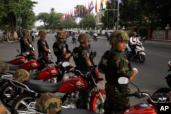FILE: Riot police block a street near the Supreme Court in Phnom Penh, Cambodia, Tuesday, Oct. 31, 2017. The Supreme Court on Tuesday uphold the lower court's decision to continue to detain opposition leader Kem Sokha who has been charged with treason, the latest in a series of moves to gain an advantage ahead of next year's general election. (AP Photo/Heng Sinith)