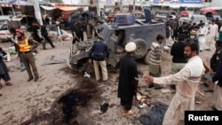 Petugas keamanan berusaha mengumpulkan bukti sesudah terjadi ledakan di Peshawar, 14/3/2014. Kelompok Pakistan Taliban yang berjuang untuk menjatuhkan pemerintahan Pakistan berada di ambang perpecahan.