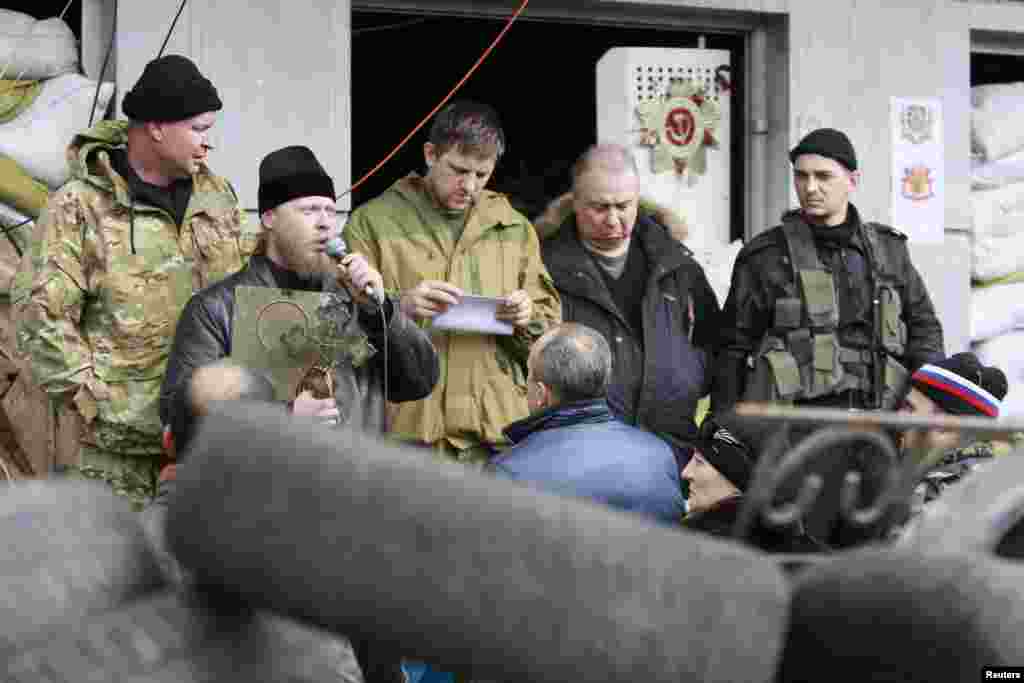 A clergyman addresses pro-Russian protesters during a rally in front of the seized office of the SBU state security service in Luhansk, eastern Ukraine, April 14, 2014. 