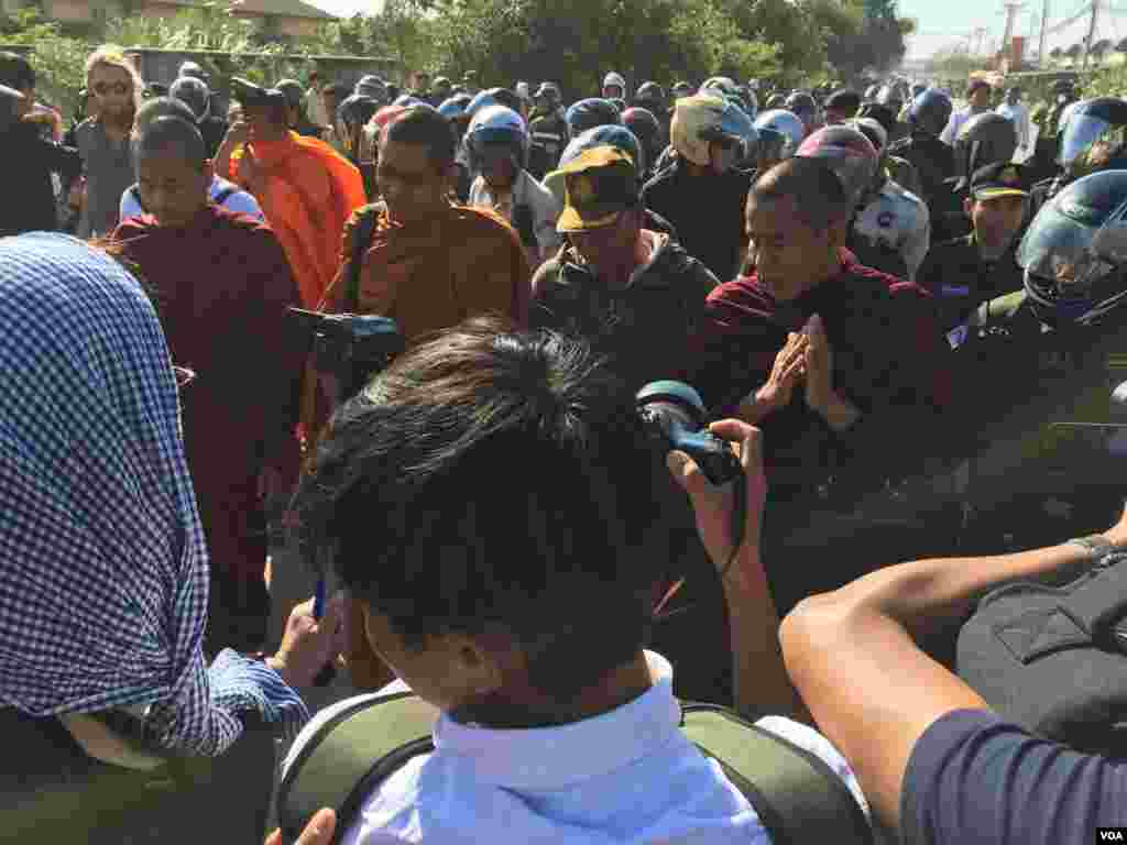 A group of Cambodian monks hold a Buddhist ceremony for protesters killed in early 2014, as police and security personnel are seen surrounding the group, on Sunday, January 03, 2016. (Hul Reaksmey/VOA Khmer) &nbsp;