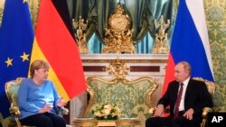 Kanselir Jerman Angela Merkel (kiri) dan Presiden Rusia Vladimir Putin dalam pertemuan di Kremlin di Moskow, Rusia, Jumat, 20 Agustus 2021. (Evgeny Odinokov, Sputnik, Kremlin Pool Photo via AP)
