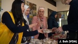 Tan Jakwani explains the sweets to customers at the Syrian Sweets Exchange event at Changing Hands Bookstore in Phoenix, Arizona.