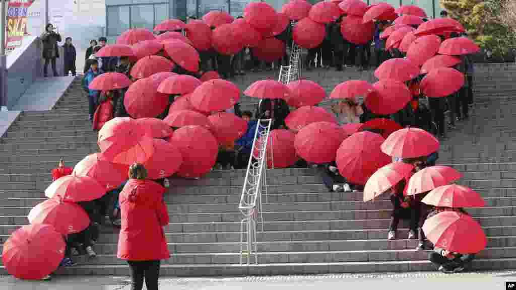 Les parapluies rouges des collégiens forment le ruban-symbole international de sensibilisation au sida à Séoul, Corée du Sud, 1er décembre 2015