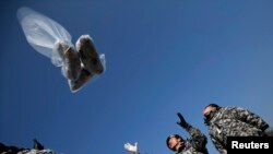 Mantan tentara Korea Utara meluncurkan balon yang membawa leaflet, CD, radio dan barang-barang lain dari Paju, sebelah utara Seoul, Korea Selatan (Foto: dok/REUTERS/Kim Hong-Ji). Lee Min-Bok, seorang pembelot dari Korea Utara yang beralih menjadi aktivis, dilaporkan telah meluncurkan balon-balon yang membawa ribuan film "The Interview" ke Korea Utara.