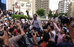 FILE - Khaled Elbalshy demonstrates with fellow journalists outside the Journalists Syndicate headquarters in Cairo, May 4, 2016, following the arrests of two reporters.