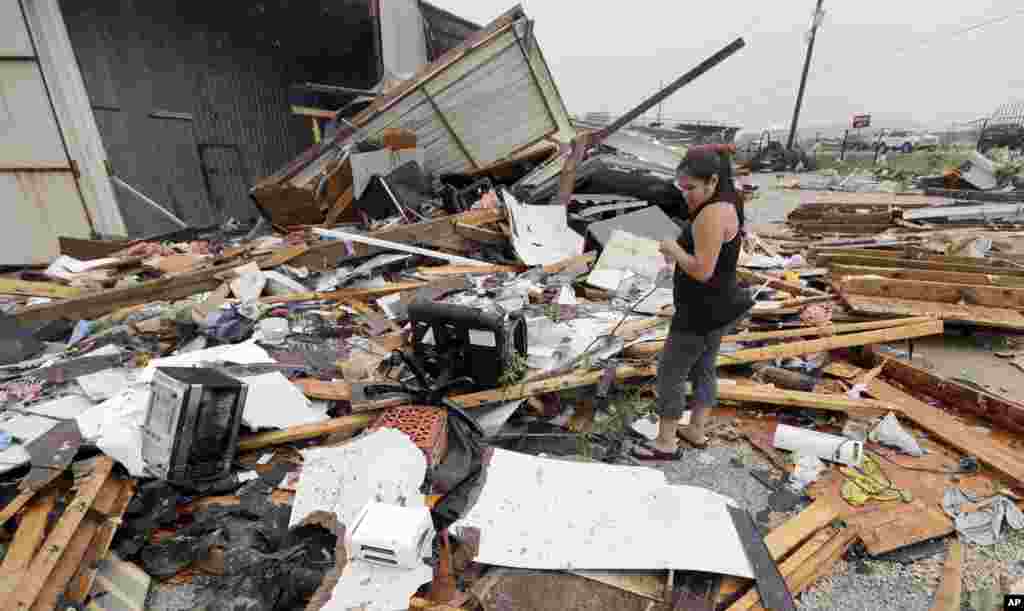 Jennifer Bryant looks over the debris from her family business destroyed by Hurricane Harvey, in Katy, Texas, Aug. 26, 2017.