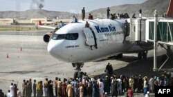 ប្រជាជន​អាហ្វហ្គានីស្ថាន​ហក់​ឡើង​លើ​យន្ដហោះ​មួយ​គ្រឿង នៅ​អាកាសយានដ្ឋាន​អន្តរជាតិ​ក្នុង​រដ្ឋធានី​កាប៊ុល ប្រទេស​អាហ្វហ្គានីស្ថាន ថ្ងៃទី១៦ ខែសីហា ឆ្នាំ២០២១។ 