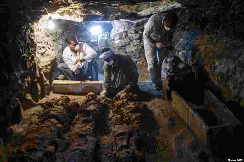Egyptian archaeological workers restore mummies and a sarcophagi in the (KAMPP 390) tomb, in Luxor, Egypt, Sept. 9, 2017.