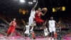 Tunisia's Makram Ben Romdhane (12) is defended by Nigeria's Koko Archibong (10) during the first half of a preliminary men's basketball game at the 2012 Summer Olympics, London, July 29, 2012.