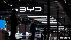 ເຈົ້າ​ໜ້າ​ທີ່​ຮັກ​ສາ​ຄວາມ​ປອດ​ໄພ​ຢືນ​ຢູ່​ບູດ​ທົ​ລົດ BYD ໃນ​ງານ​ວາງ​ສະ​ແດງ​ລົດ ຊຽງ​ໄຮ້, ຈີນ, 19 ເມ​ສາ 2023.REUTERS/Aly Song
