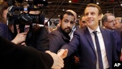 FILE - Centrist presidential candidate Emmanuel Macron (C) is flanked by his bodyguard, Alexandre Benalla (L) while visiting the Agriculture Fair in Paris, March 1, 2017.