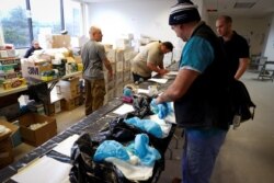 Will Swanson, a registered nurse from Columbia University, picks up personal protective equipment and other supplies at a New York State emergency operations incident command center during an outbreak in New Rochelle, N.Y., March 17, 2020.