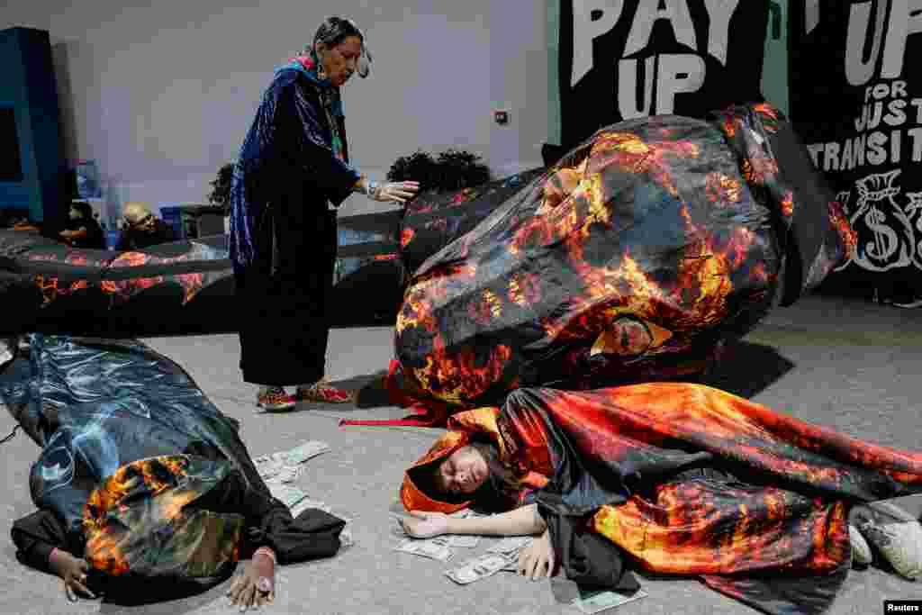 Activists lie next to fake currency bills as they participate in a protest during the United Nations climate change conference COP29 in Baku, Azerbaijan.
