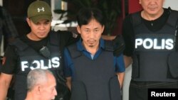 Warga Korut, Ri Jong Chol (tengah), yang telah ditahan sejak 17 Februari, diserahkan kepada petugas imigrasi Malaysia untuk dideportasi (foto: dok).