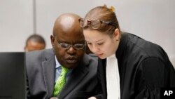 Fidèle Babala Wandu of the Democratic Republic of Congo, left, sits in the court room of the International Criminal Court where judges delivered verdicts against former Congolese Vice President Jean-Pierre Bemba for interfering with witnesses in Bemba's war crimes trial, in The Hague, Netherlands, Wednesday, Oct. 19, 2016. (Michael Kooren via AP)