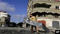 បុរសប៉ាឡេះស្ទីន​​​ម្នាក់​​​​​​រើស​​​កំទេច​​​ដែក​​​នៅ​​​ជិត​​​ជំរុំ​​​Hamas​​​មួយ​​​កន្លែង ក្រោយ​​​ការ​​​វាយ​​​ប្រហារ​​​តាម​​​អាកាស