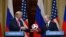 FINLAND -- Russia's President Vladimir Putin (R) offers a ball of the 2018 football World Cup to US President Donald Trump during a joint press conference after a meeting at the Presidential Palace in Helsinki, on July 16, 2018.