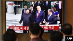 FILE - People watch a television news screen showing U.S. President Donald Trump, South Korean Moon Jae-in and North Korean leader Kim Jong Un meeting at the truce village of Panmunjom in the DMZ, at a railway station in Seoul, June 30, 2019. 