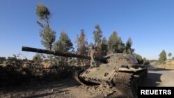 Umuhungu wicaye ku modoka y'intambara yangirikiye mu rugamba rw'abasirikare ba Etiyopiya n'ab'intara ya Tigreya