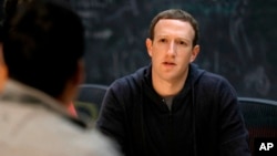 FILE - Facebook CEO Mark Zuckerberg meets with entrepreneurs and innovators during a round-table discussion in St. Louis, Nov. 9, 2017. Facebook announced an effort to remove false information that could lead to violence.