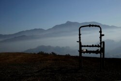 A charred lawn chair overlooks a valley filled with smoke from the Kincade Fire near Healdsburg, Calif., Nov. 1, 2019.