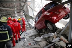 Rescue workers search a collapsed building from an early morning earthquake in Tainan, Taiwan, Feb. 6, 2016.