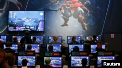 Visitors play the "Final Fantasy XIV: A Realm Reborn" video game at an exhibition stand during the Gamescom 2014 fair in Cologne August 13, 2014. 