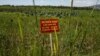 A warning sign stands in a field contaminated with dioxin near Danang airport, during a ceremony marking the start of a project to clean up dioxin left over from the Vietnam War, at a former U.S. military base in Danang, Vietnam, August 9, 2012.