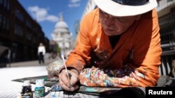 Ben Wilson, artist, paints on the Millennium Bridge, London, Britain, August 21, 2023. (REUTERS/Anna Gordon)