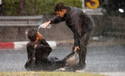 A demonstrator gets assistance during a protest of the government's handling of the coronavirus pandemic, in Bangkok, Thailand.