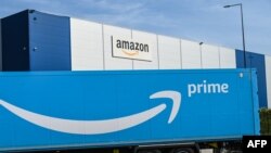 Truk pengiriman Amazon diparkir di luar pusat logistik Amazon di Lauwin-Planque, Perancis utara, pada 16 April 2020. (Foto: AFP)