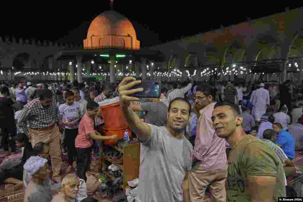 After the end of the rituals, Muslims pose for a selfie in Amr Ibn al-As mosque, in old Cairo, Egypt, May 31, 2019. 
