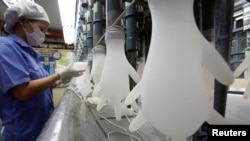 Seorang pekerja memeriksa sarung tangan di pabrik Top Glove di Klang di luar Kuala Lumpur, Malaysia, 11 Januari 2010. (Foto: Reuters)