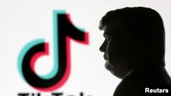 ເຄື່ອງໝາຍຂອງແອັປ TikTok ແລະຮູບປັ້ນຂອງທ່ານດໍໂນລ ທຣຳ ຖ່າຍເມື່ອວັນທີ 15 ມັງກອນ 2025. REUTERS/Dado Ruvic/Illustration/File Photo