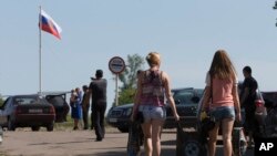 2일 우크라이나 동부 루간스크에서 러시아계 주민들이 폭력 사태를 피해 러시아로 향하고 있다.