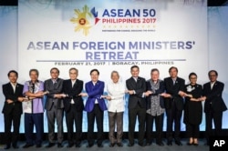 FILE - In this photo provided by Presidential Communications Operations Office ASEAN, foreign ministers from the Association of Southeast Asian Nations (ASEAN) link arms during the ASEAN Foreign Ministers' Retreat in Boracay, Aklan province, central Philippines, Feb. 21, 2017.