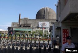 FILE - A police officer stands guard in front of Taiwan's nuclear power plant during a safety drill in Pingtung county, southern Taiwan.