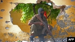 Un soldat somalien monte la garde près du site où les militants d'Al-Shabab ont perpétré un attentat-suicide contre une base de renseignement militaire à Mogadiscio, le 21 juin 2015.