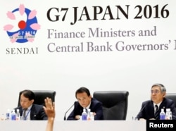 Japan's Finance Minister Taro Aso, center, and Bank of Japan Governor Haruhiko Kuroda, right, attend a news conference after the G-7 finance ministers and central bankers meeting in Sendai, Miyagi prefecture, Japan, May 21, 2016.