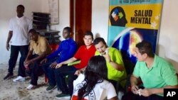 In this photo released by Colombia's Ombudsman's Office, an International Red Cross officer talks to six hostages freed by rebels of the National Liberation Army, ELN, in a village in the Choco department of western Colombia, Sep. 12, 2018. 