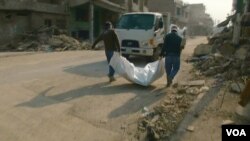  Two rescue worker from Mosul Mayoralty office remove a plastic bag containing a dead body found under the rubble of the Old City in Mosul, January 2018. (K Omar/VOA)