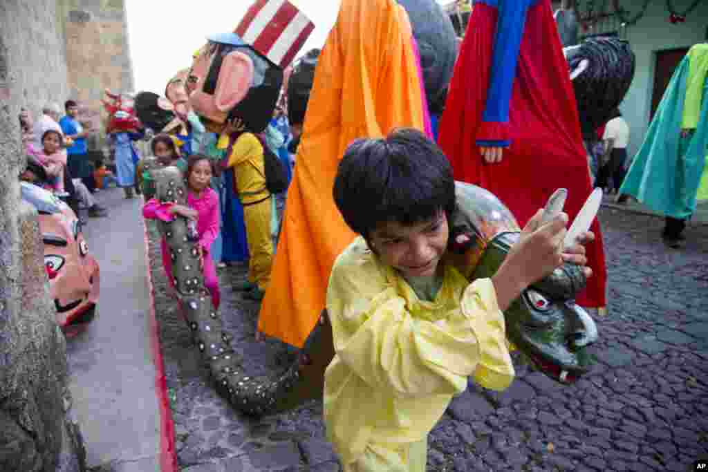 Children carry a snake made out of rags and paper as they take part in the traditional dance of &quot;Los Gigantes,&quot; or &quot;The Giants,&quot; during Christmas celebrations on Christmas Eve in Antigua Guatemala, Dec. 24, 2014.