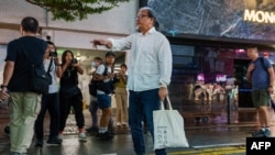 Performance artist Sanmu Chen gestures to trace the Chinese characters of 8964 referring to the 1989 Tiananmen Square massacre, along the Causeway Bay in Hong Kong on June 3, 2024 on the eve of the 35th anniversary of Beijing’s 1989 Tiananmen Square massacre.