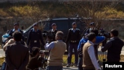 A car carrying former Pakistani President Pervez Musharraf, drives past members of the media as he leaves the special court formed to try him for treason in Islamabad Feb. 18, 2014.